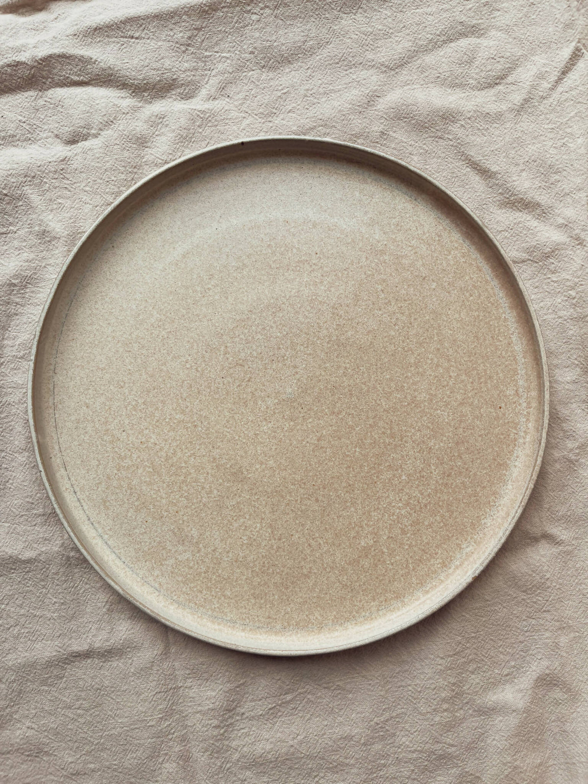 Assiette ronde en céramique beige sable moucheté, style classique Algue