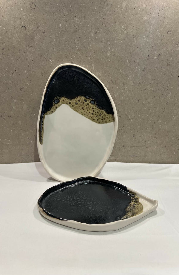 Grande assiette ovale en céramique, noir et blanc, bords légèrement contrastés