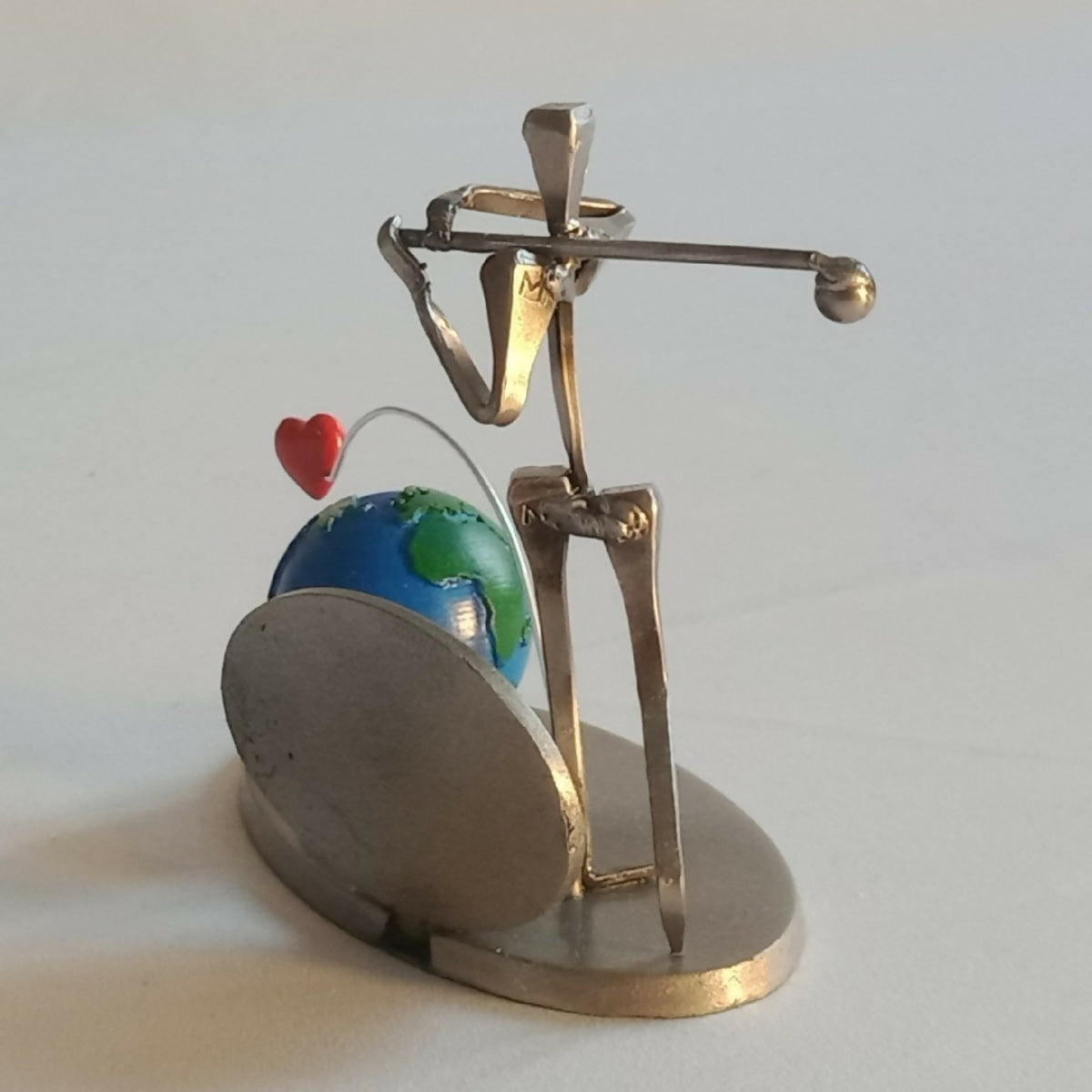 Statuette de golfeur en métal doré, globe bleu-vert, arc métallique et cœur rouge