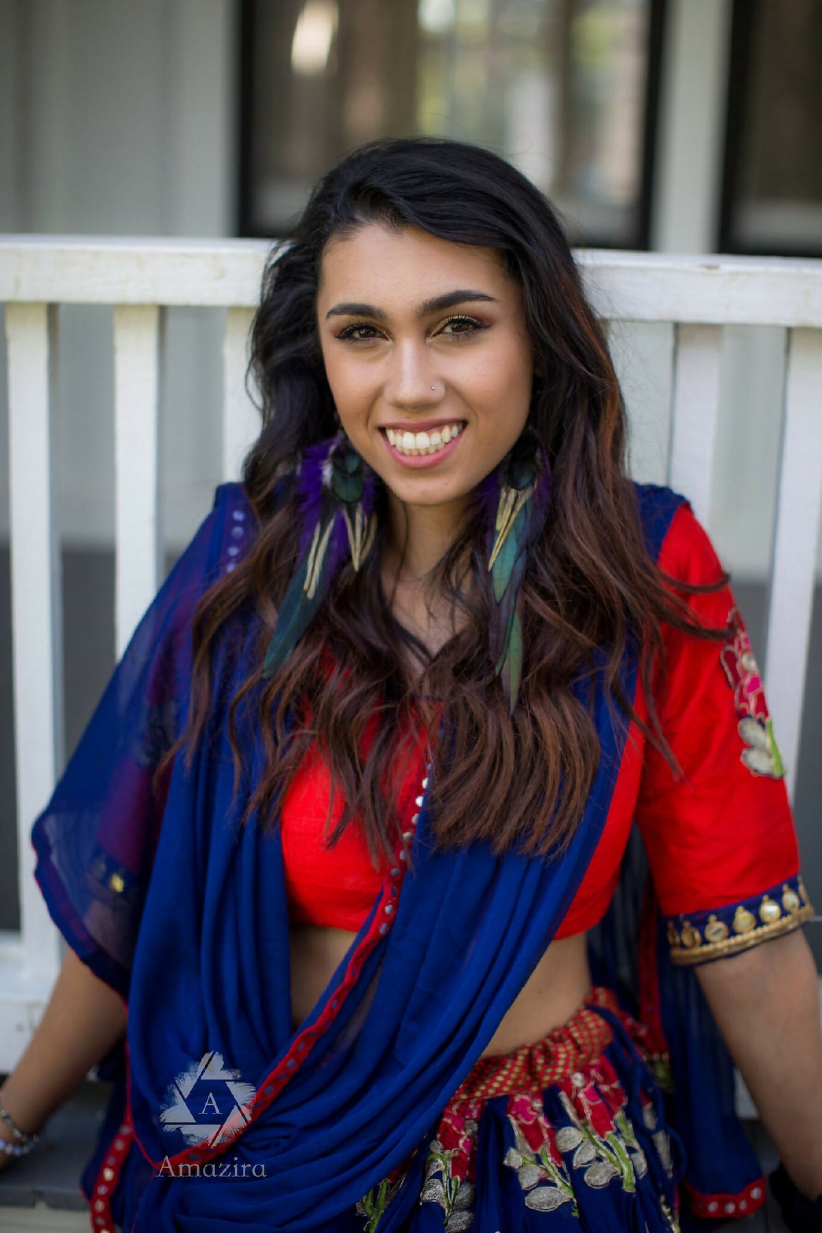 Boucles d’oreilles pendantes en plumes vertes et violettes, portées par une femme