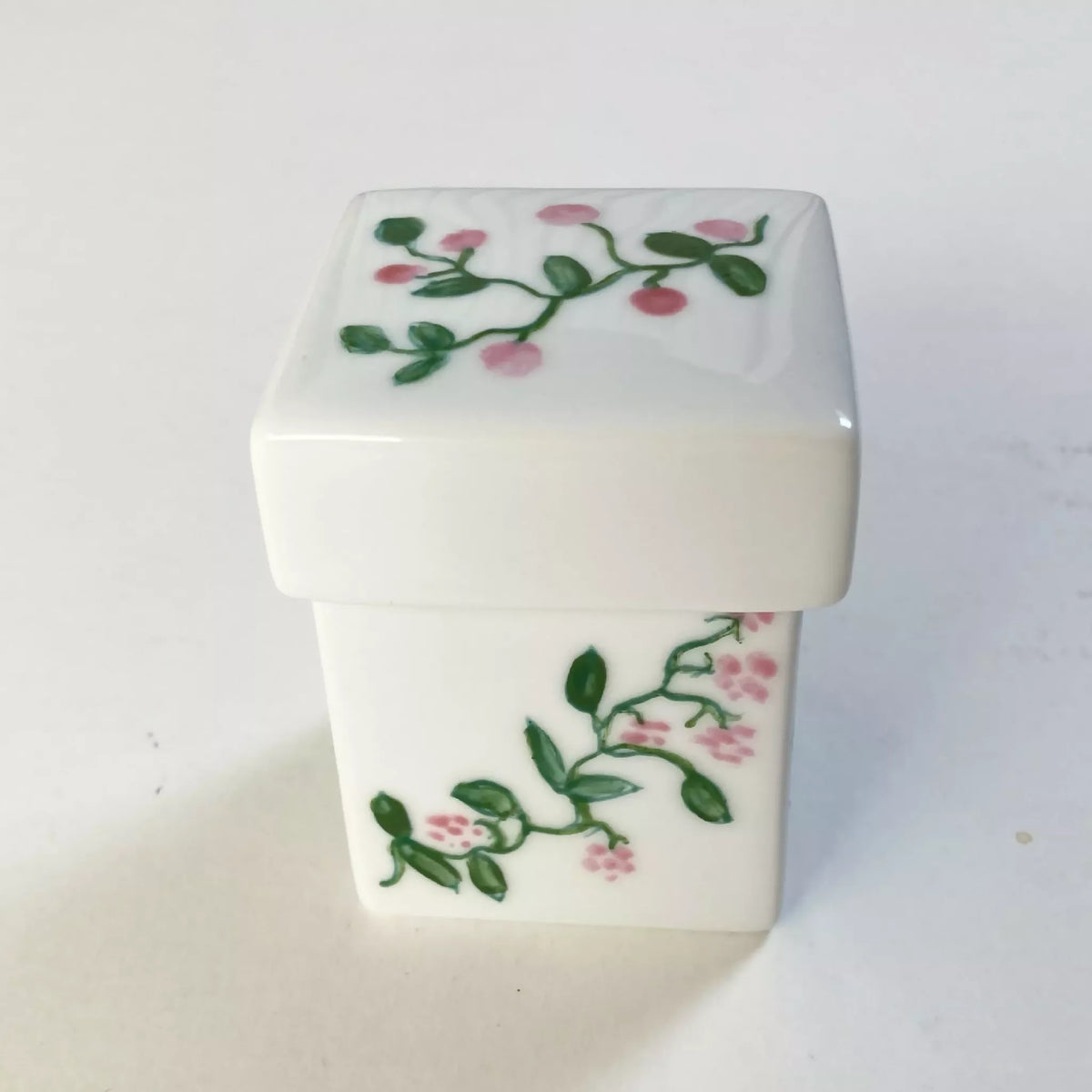 Boîte à bijoux en porcelaine blanche, fleurs roses sur couvercle et face.