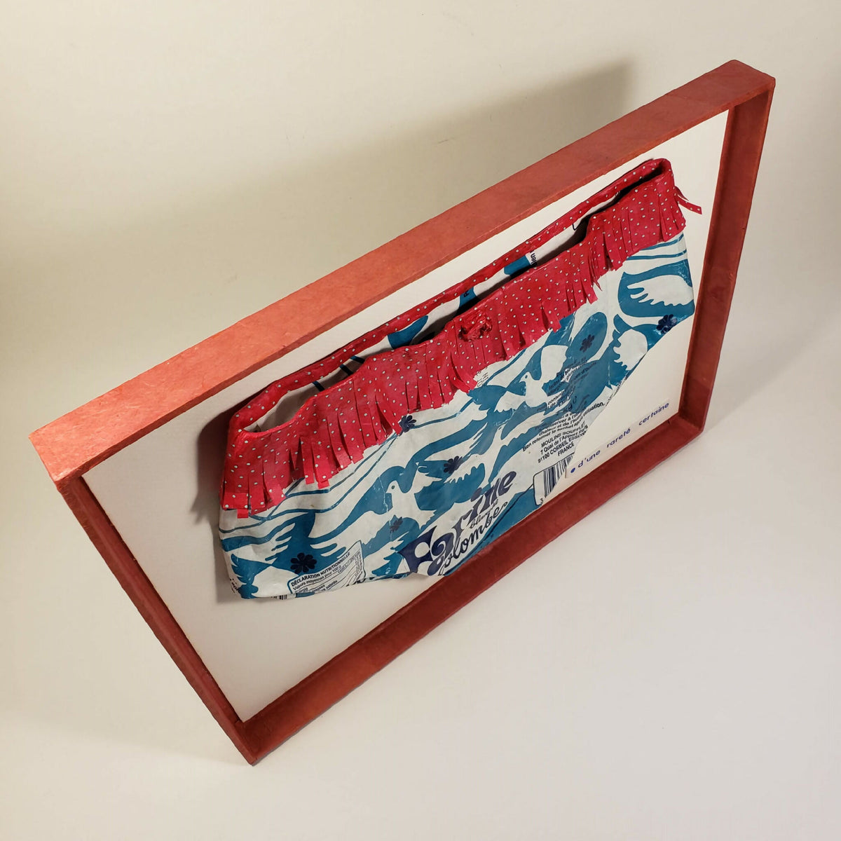 Culotte encadrée rouge à volants et imprimé bleu oiseaux, vue en biais.