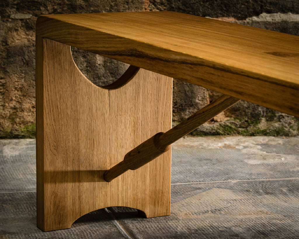 Banc en bois clair : ouverture demi-lune, renfort en bois sous le plateau, vue de côté.