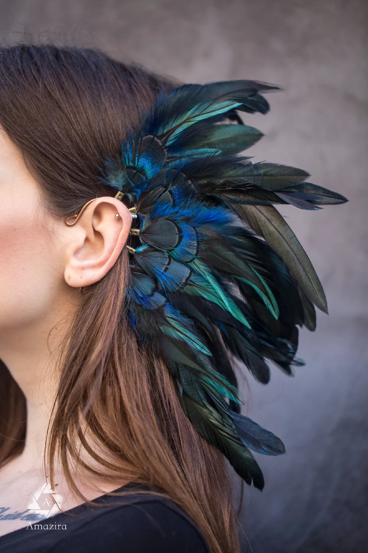 Manchette d’oreille avec grande plume bleu et vert foncé, portée sur l’oreille
