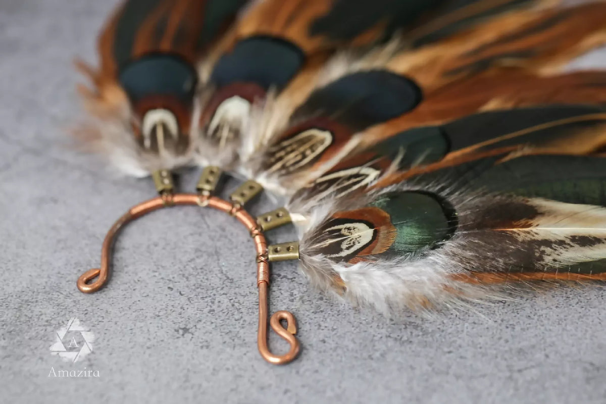 Manchette d’oreille vue de près : plumes bicolores et base à attaches métalliques