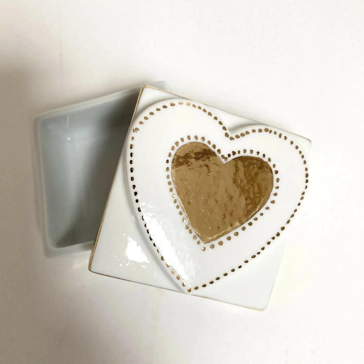 Boîte à bijoux blanche à cœur doré, couvercle ouvert montrant l’intérieur gris