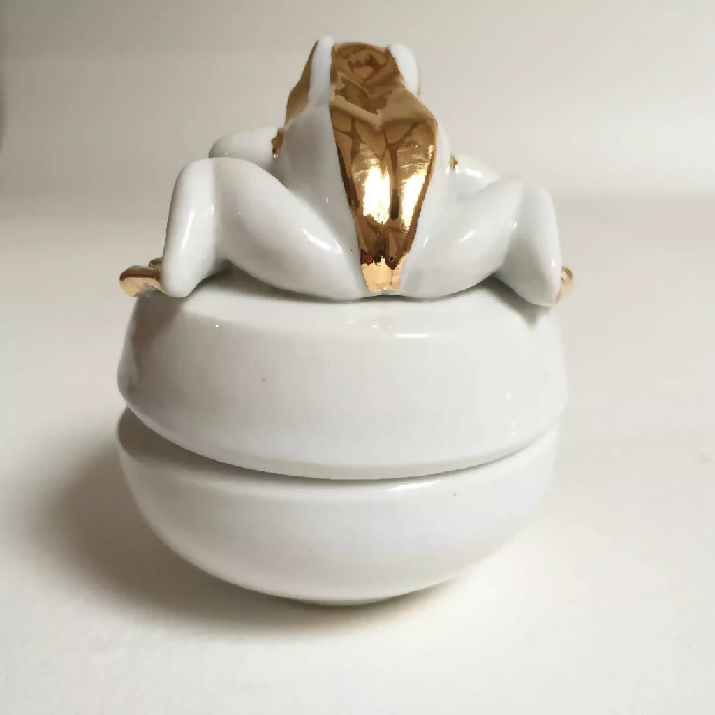 Boîte à bijoux grenouille blanche, couvercle ouvert vers l’arrière, finition dorée brillante.