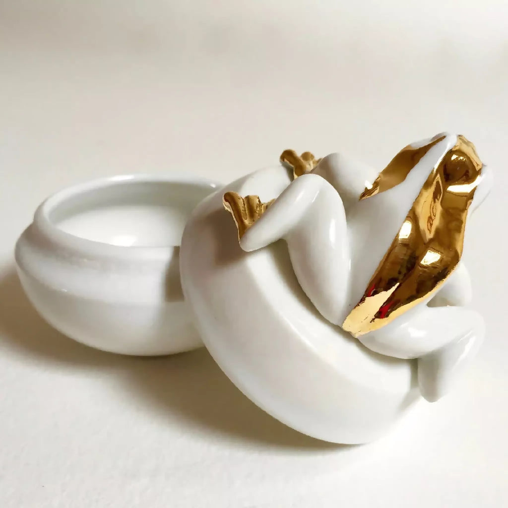 Boîte à bijoux grenouille blanche avec ouverture du dessus, finitions dorées sur le corps.