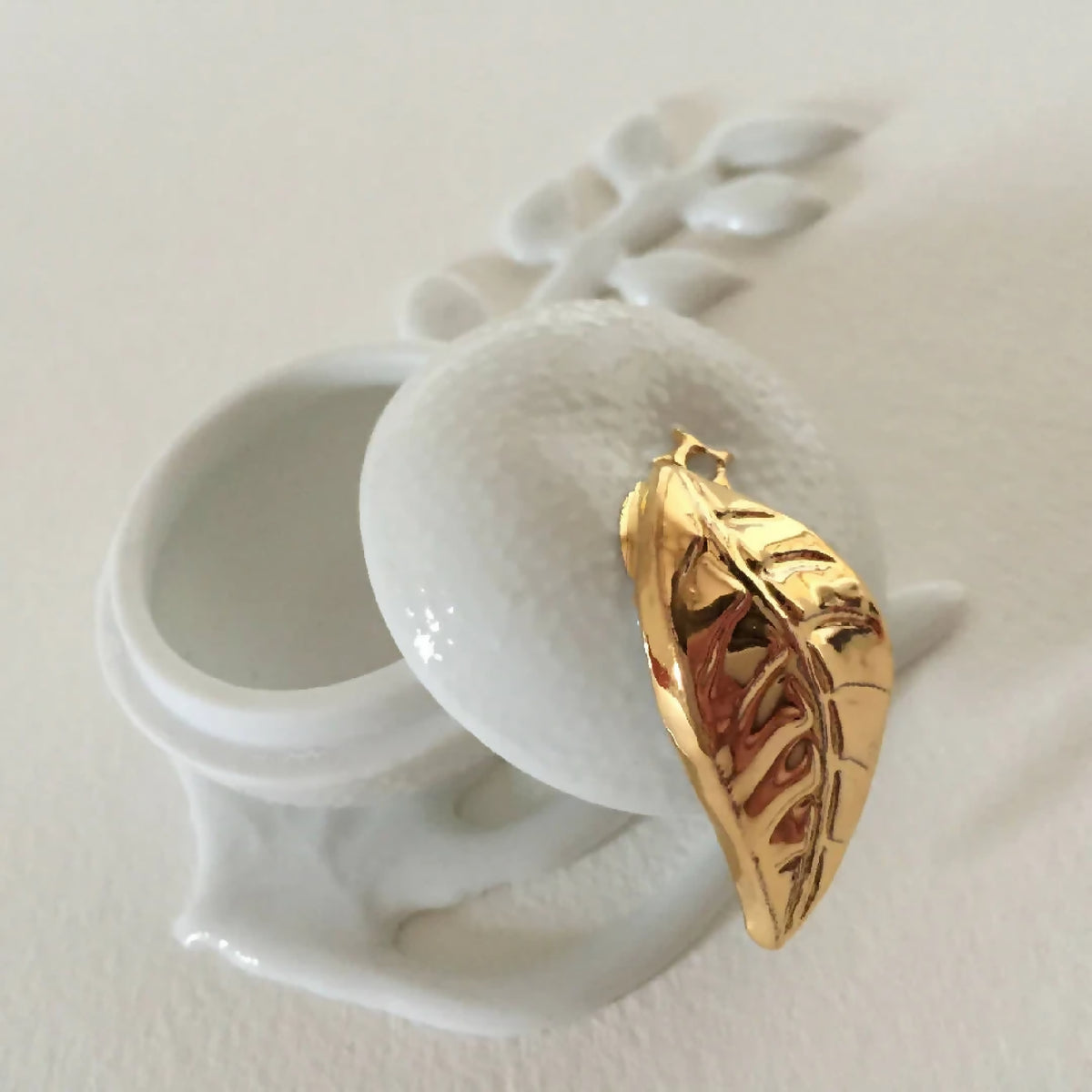 Boîte à bijoux en porcelaine blanche, détail du fermoir doré en forme de feuille