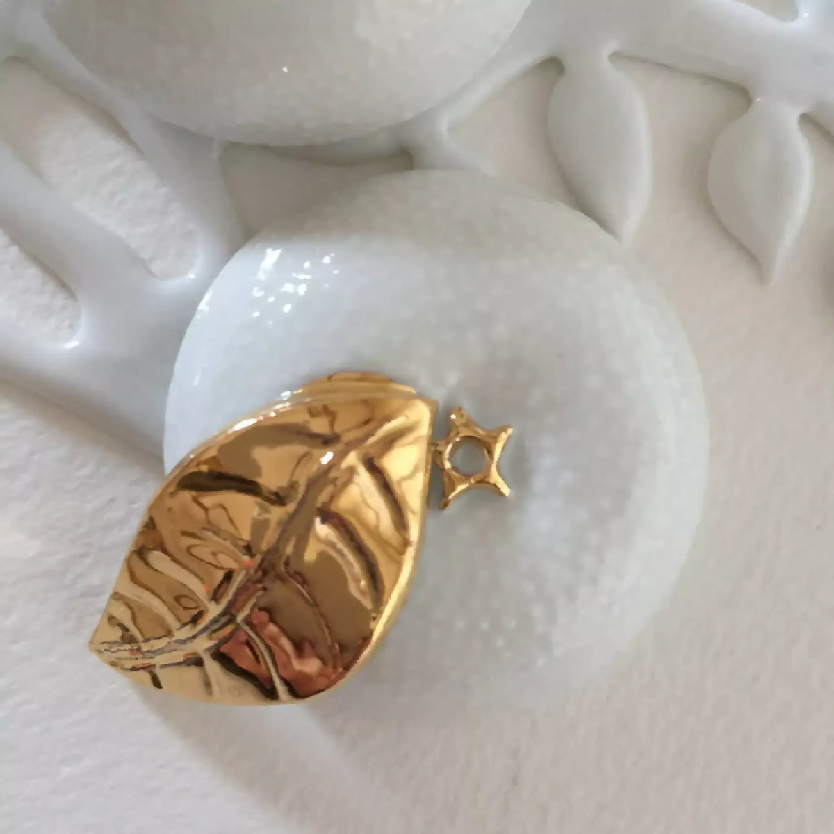 Boîte à bijoux en porcelaine blanche, gros plan du fermoir doré en forme de feuille