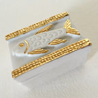 Boîte à bijoux blanche vue inclinée, motif poisson nacré et bordures dorées tressées