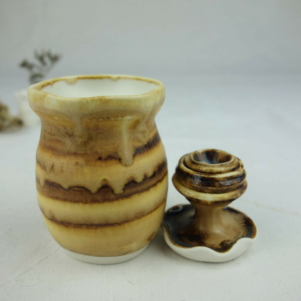 Petit pot en céramique beige et brun, motif marbré, vue de face avec base évasée