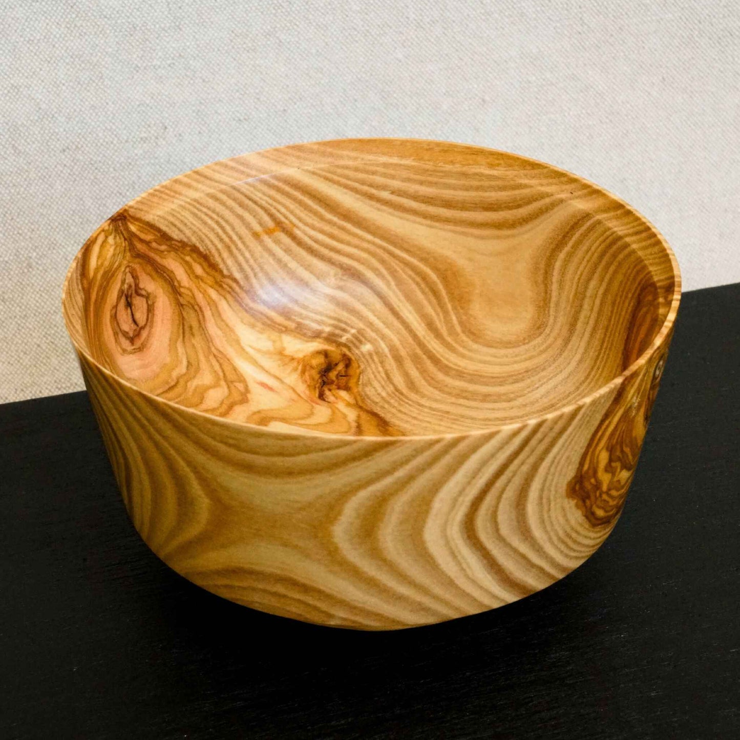 Bol en bois rond, intérieur clair avec veines ondulées et nœud latéral