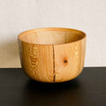 Bol en bois clair avec large nœud sombre et couture verticale centrale