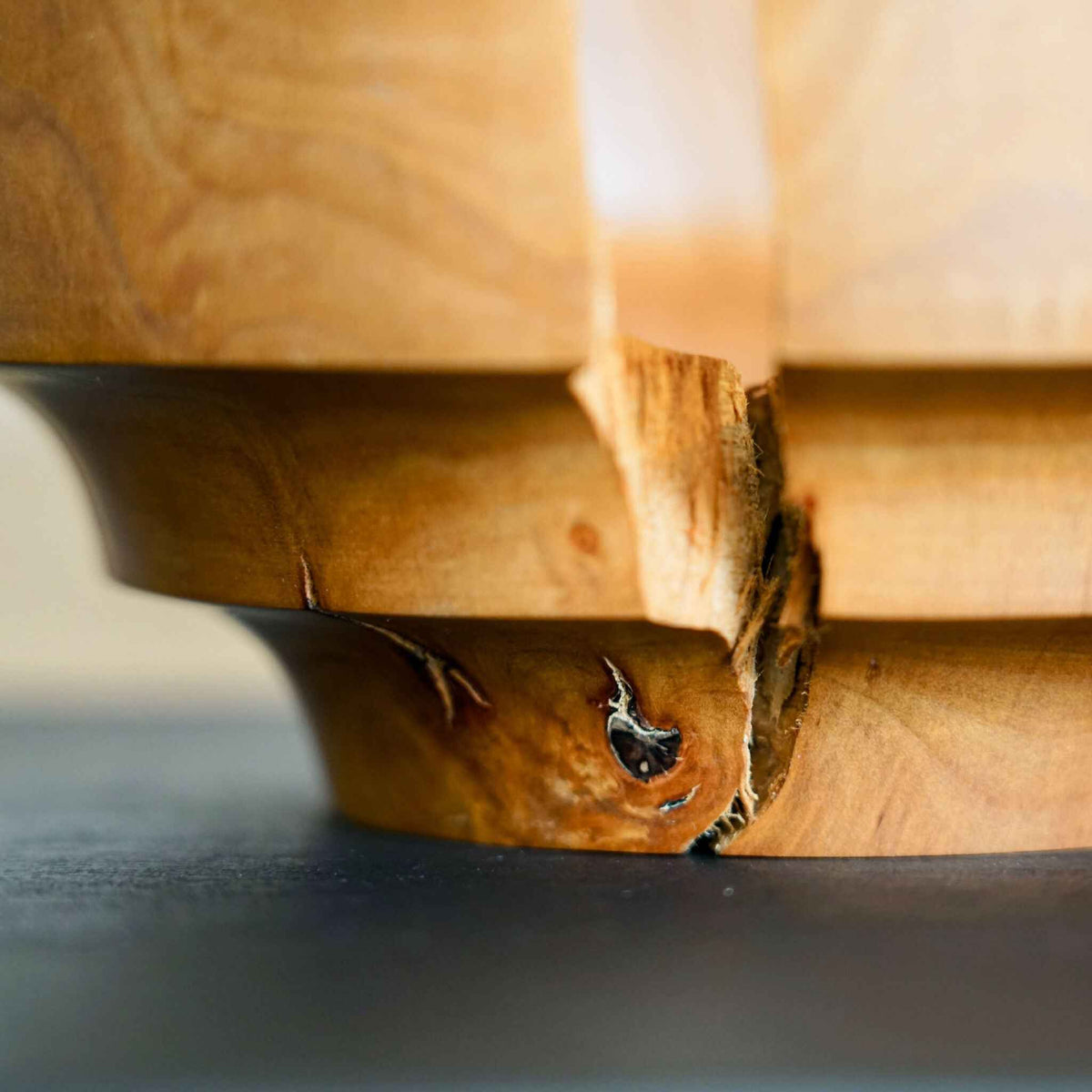 Bol en bois naturel, gros plan sur la jointure entre panneaux, nœuds visibles
