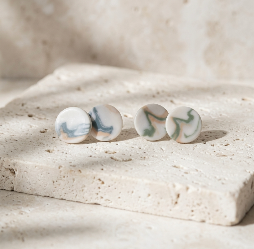 Paire de clous d’oreille ronds en porcelaine blanche, motifs marbrés bleu et gris.