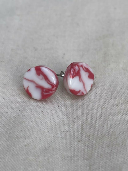 Clous d’oreilles en porcelaine, disques marbrés blanc et rouge, avec tige métallique.