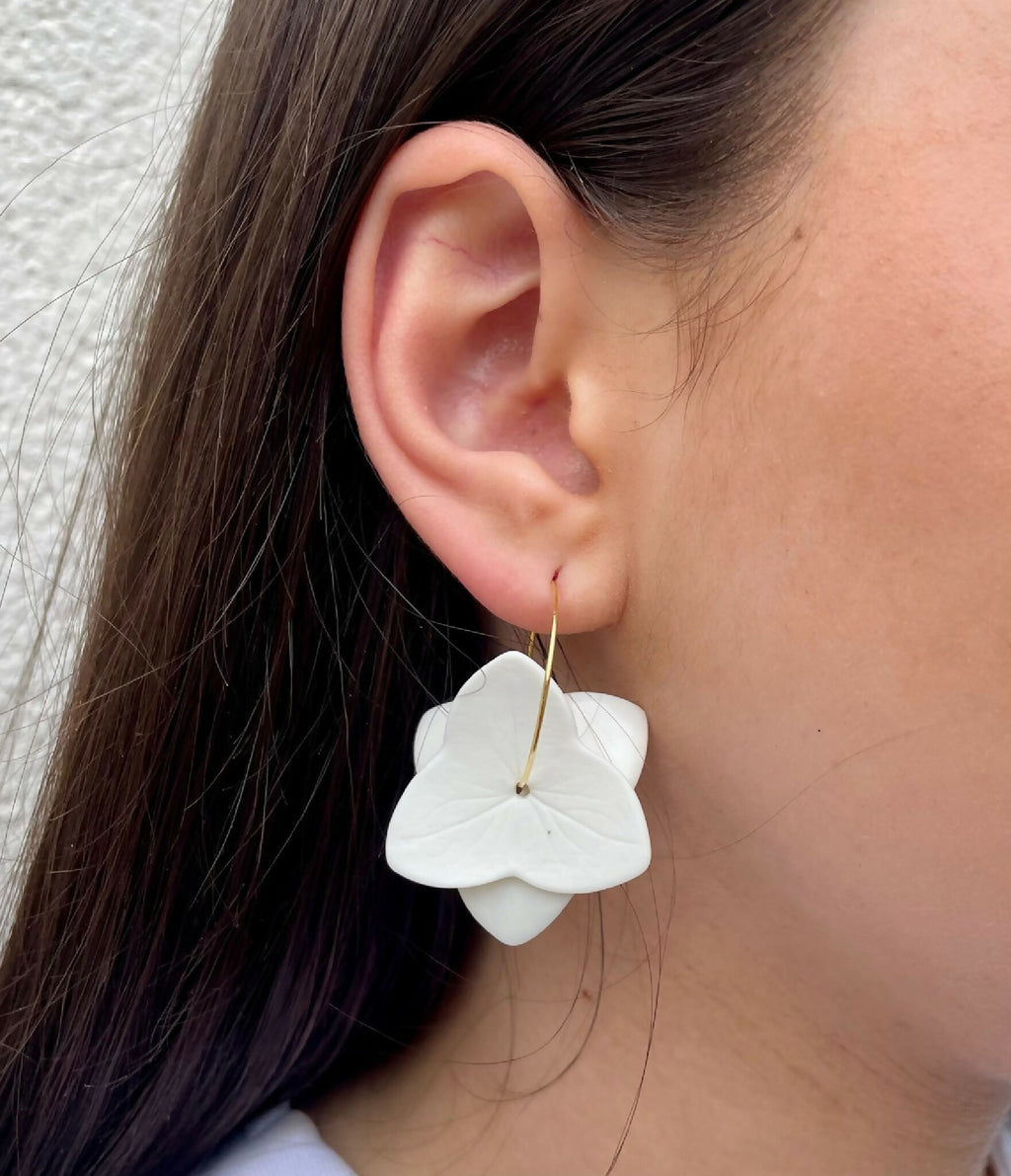 Boucles d’oreille en porcelaine, fleurs blanches portées, vue de profil