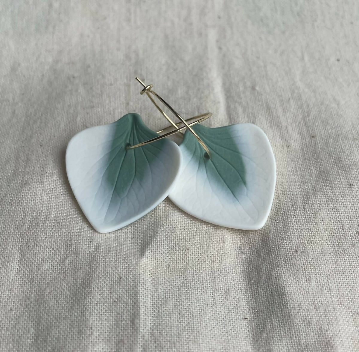 Boucles d’oreille créoles en porcelaine bleu clair, forme de pétales, attaches dorées.