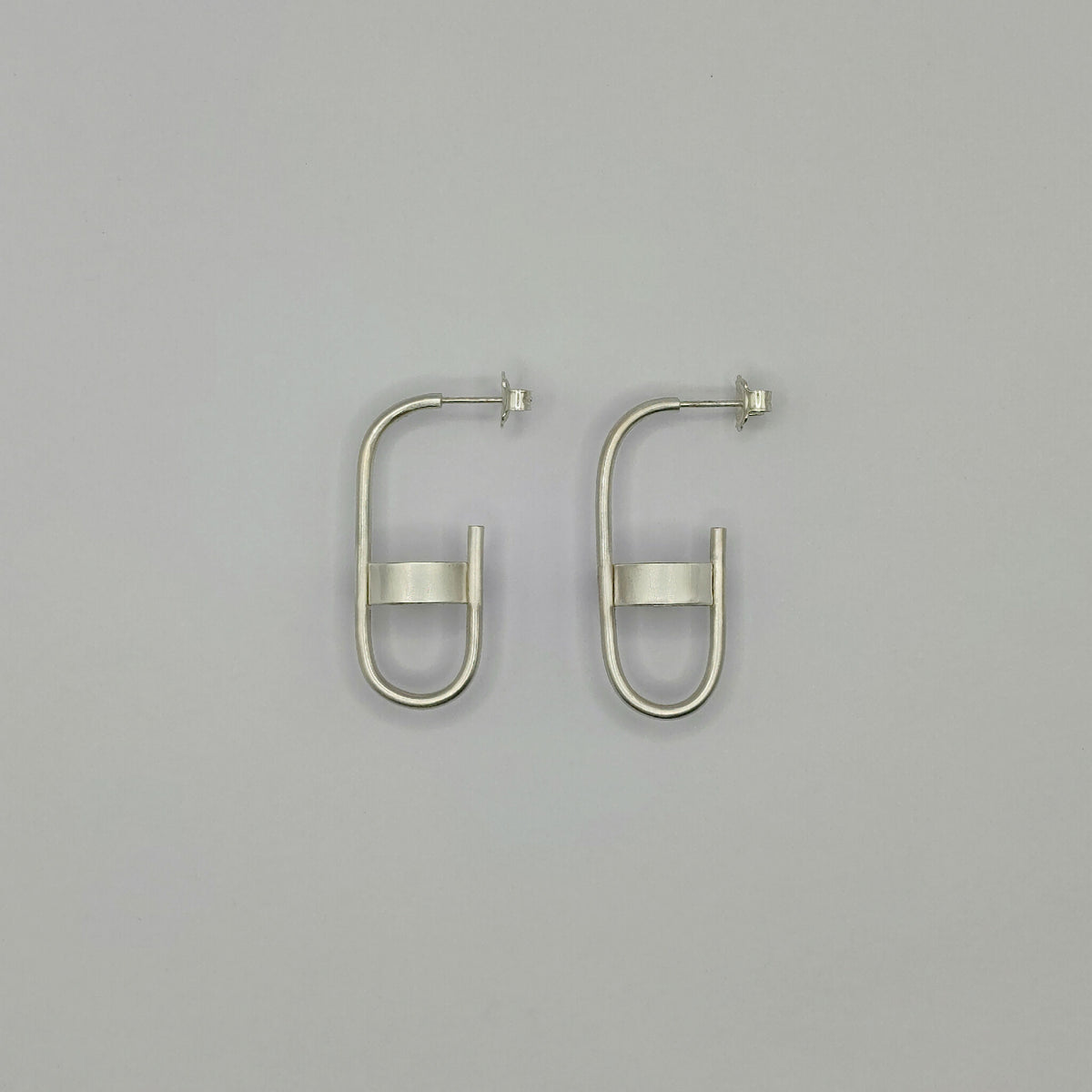 Boucles d’oreille anneaux argentés, vue de face avec barre rectangulaire
