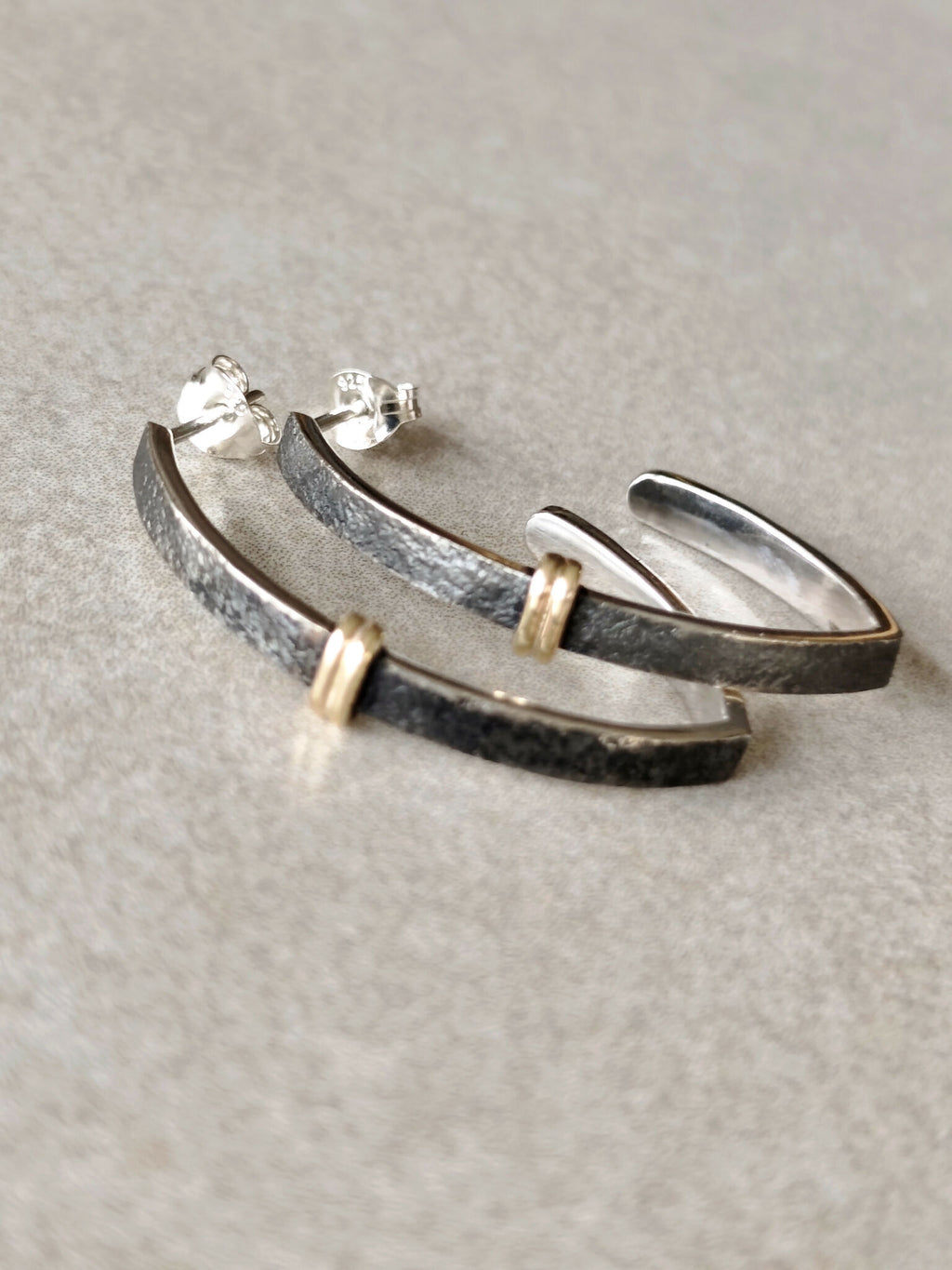Paire de boucles d’oreilles courbes noires, finitions argentées et attaches dorées