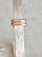Détail du fermoir des boucles d’oreilles courbes : barre dorée et attache arrondie