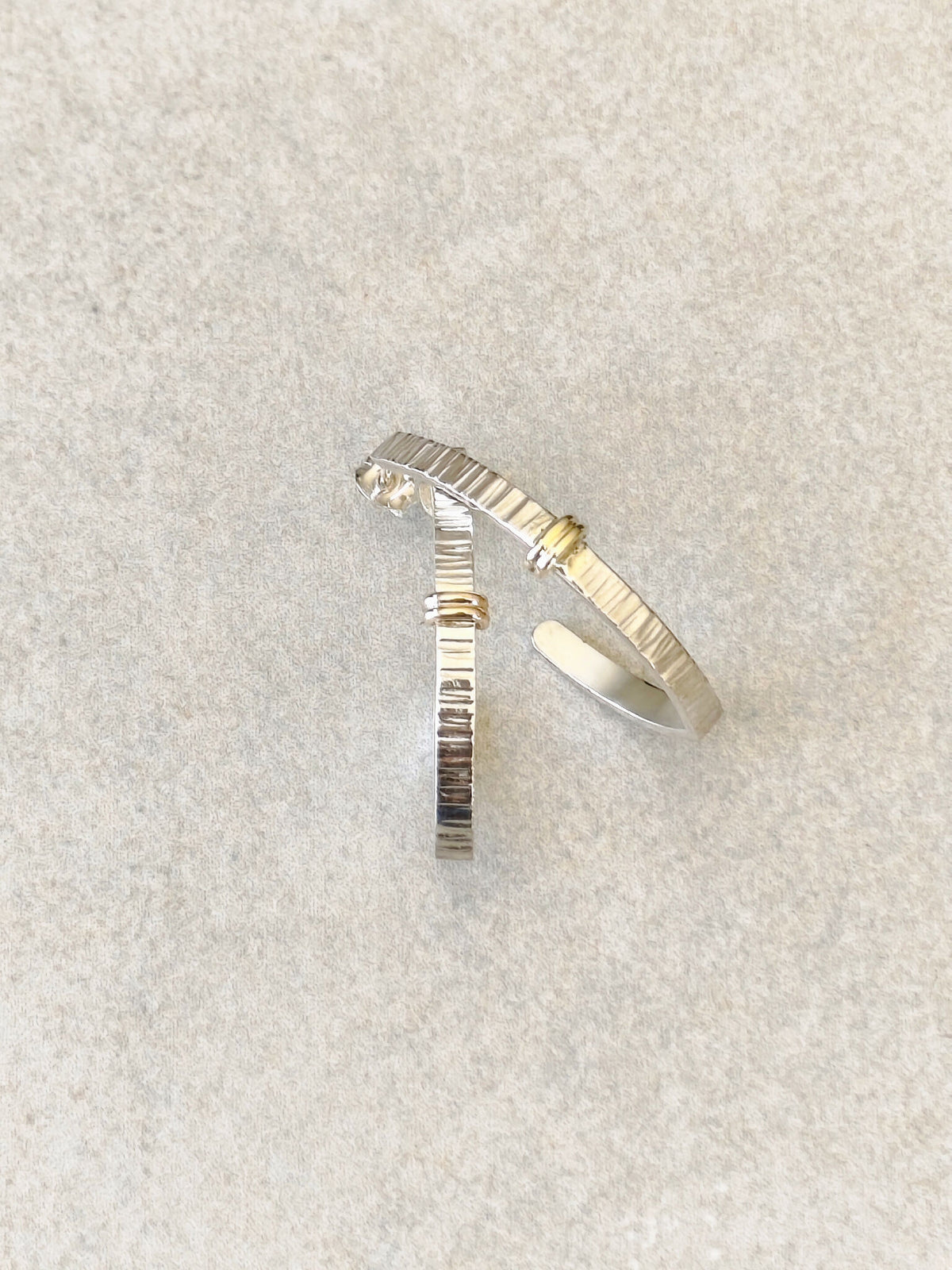 Boucles d’oreilles courbées argent et doré, texture striée, petit point brillant