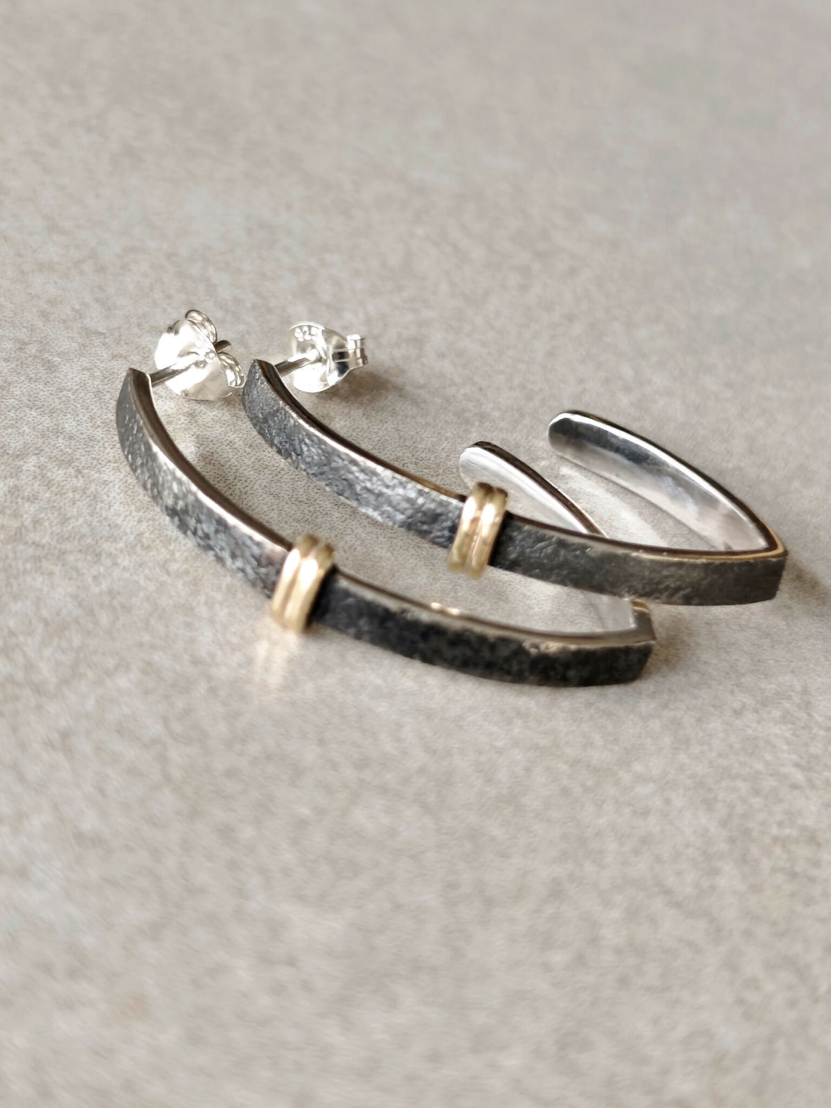 Paire de boucles d’oreilles courbes noires, finitions argentées et attaches dorées