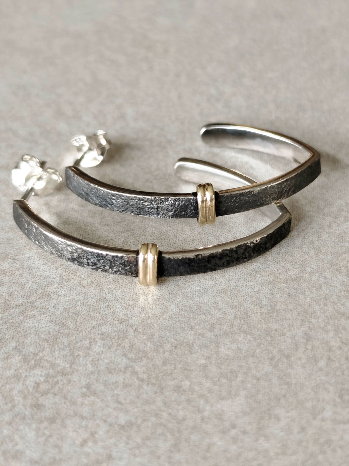 Boucles d’oreilles courbes noires avec liseré argenté et attaches dorées