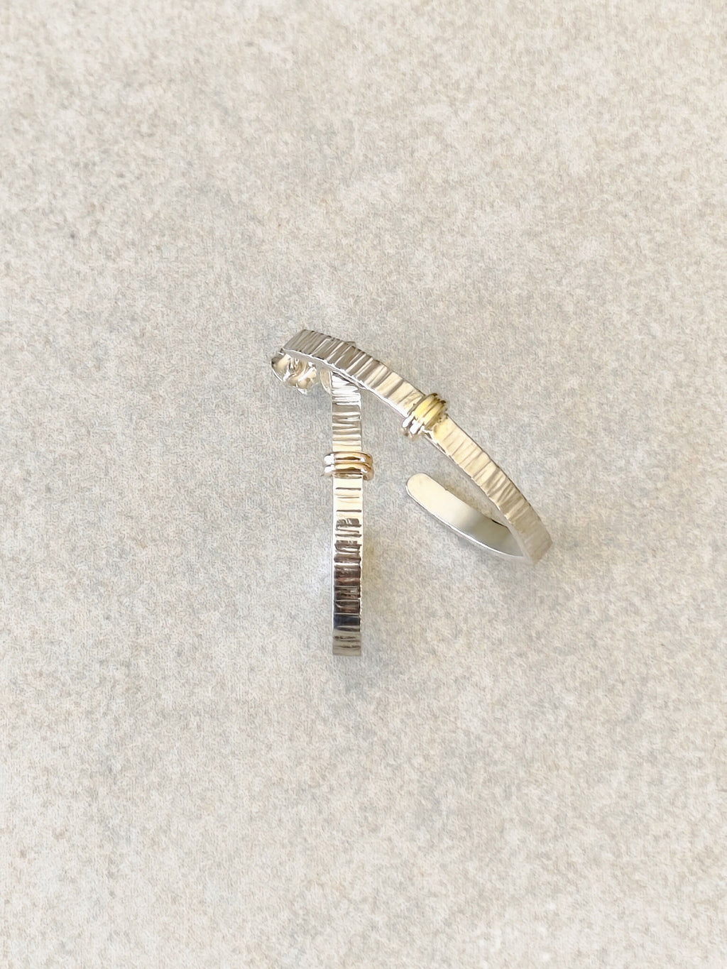Boucles d’oreilles courbées argent et doré, texture striée, petit point brillant
