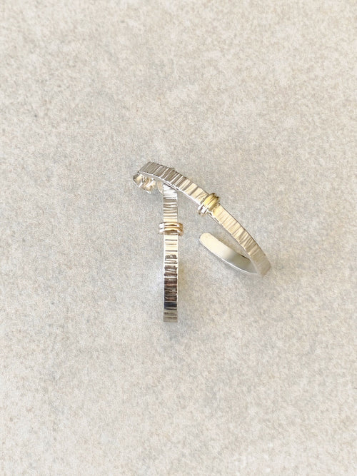 Boucles d’oreilles courbées argent et doré, texture striée, petit point brillant