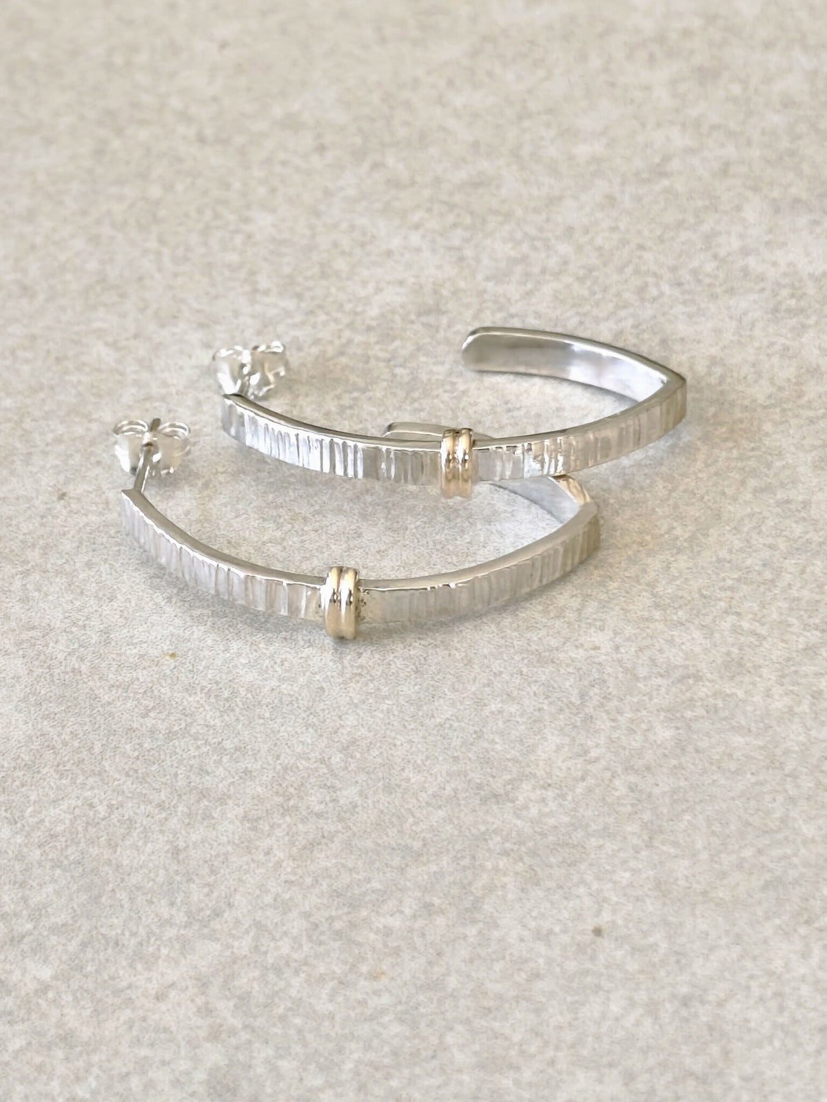 Paire de boucles d’oreilles courbées argentées avec inserts dorés, style rayé