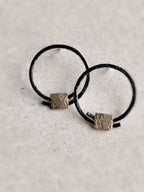Boucles d’oreilles anneaux noirs, carrés texturés dorés à la base