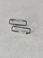 Boucles d’oreilles rectangulaires vues de côté, contours foncés et plaquettes striées