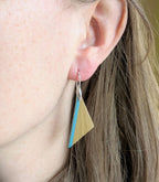 Boucles d’oreilles triangulaires paille dorée et turquoise, sur crochets argent, portées.