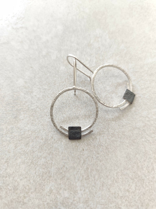 Boucles d’oreilles pendantes: deux anneaux argentés, carré noir en pendentif