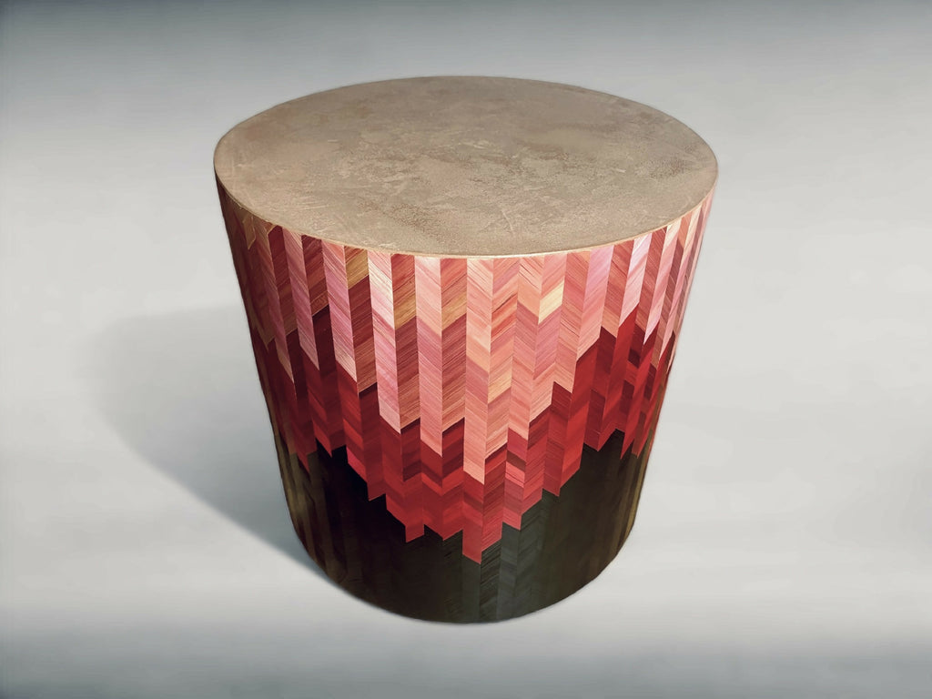 Bout de canapé rond, vue trois-quarts : motif chevrons rouge et beige sur base sombre.