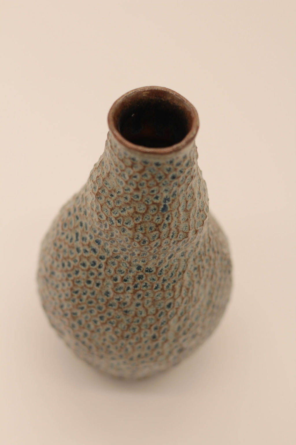 Petite bouteille en céramique bleu-gris, vue rapprochée du goulot brun intérieur