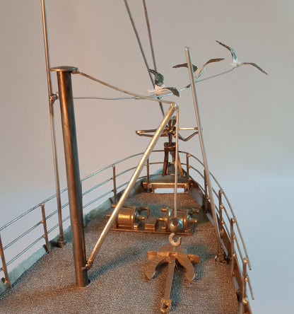 Maquette du Titanic en acier recyclé, vue latérale avec mâts et figurines décoratives