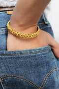Bracelet tressé doré à perles, porté à la cheville
