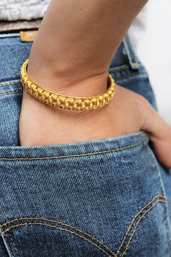 Bracelet tressé doré à perles, porté à la cheville