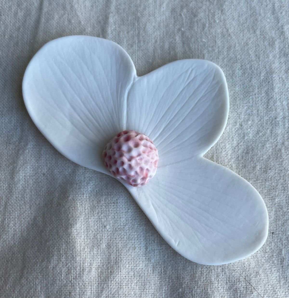 Broche florale en porcelaine aimantée, pétales bleu clair, centre rose tacheté.