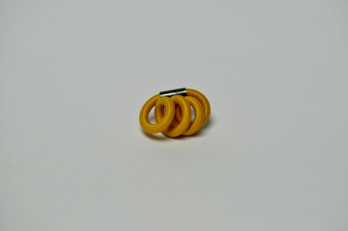 Broche entrelacée jaune, arrière avec tige/attache métallique.