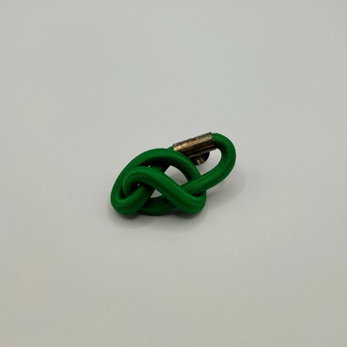 Broche d'entrelacs vert, vue de profil avec attache métallique argent