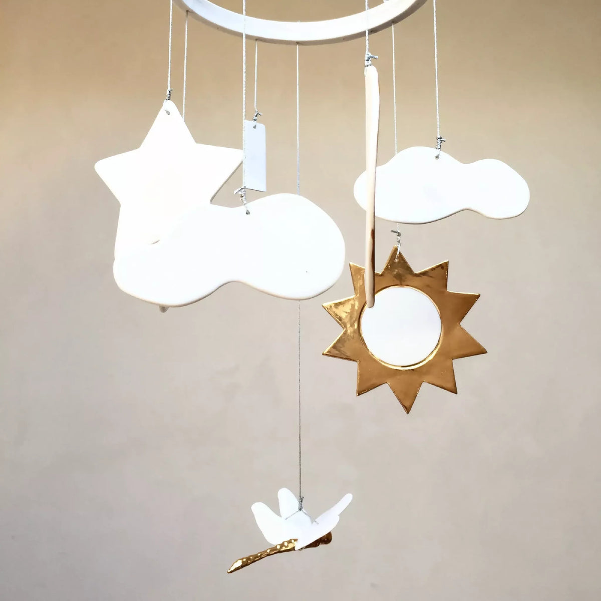 Mobile de naissance : étoiles dorées, nuages blancs et lune, anneau suspendu.