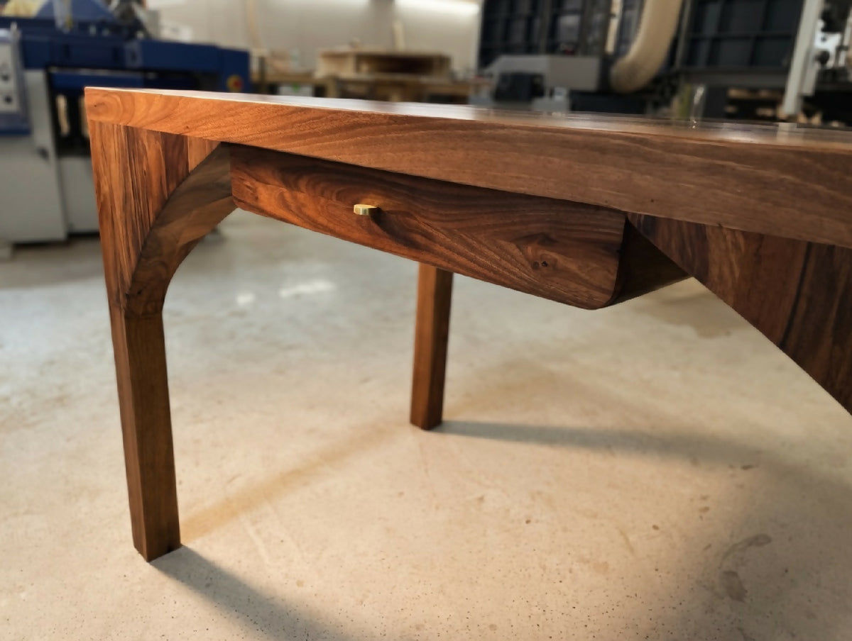 Bureau en bois massif, vue latérale avec traverse sculptée et piétement stable