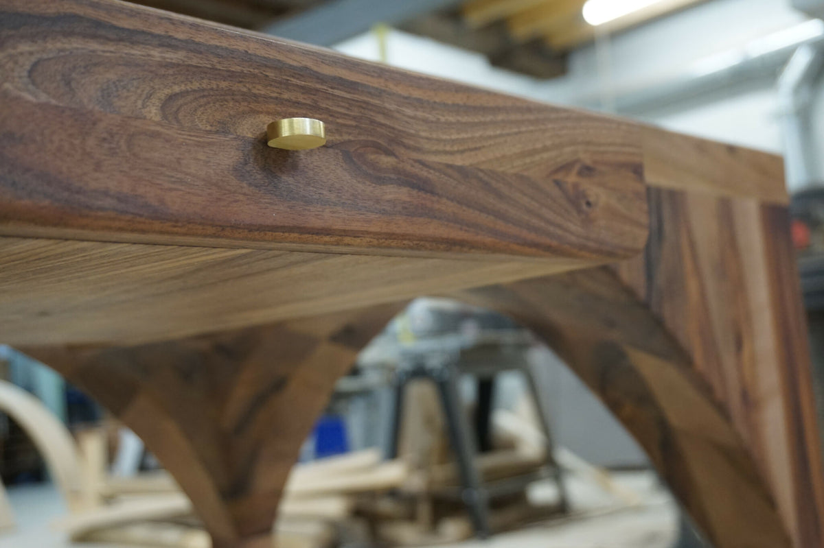 Bureau en bois massif, gros plan sur un insert métallique couleur laiton