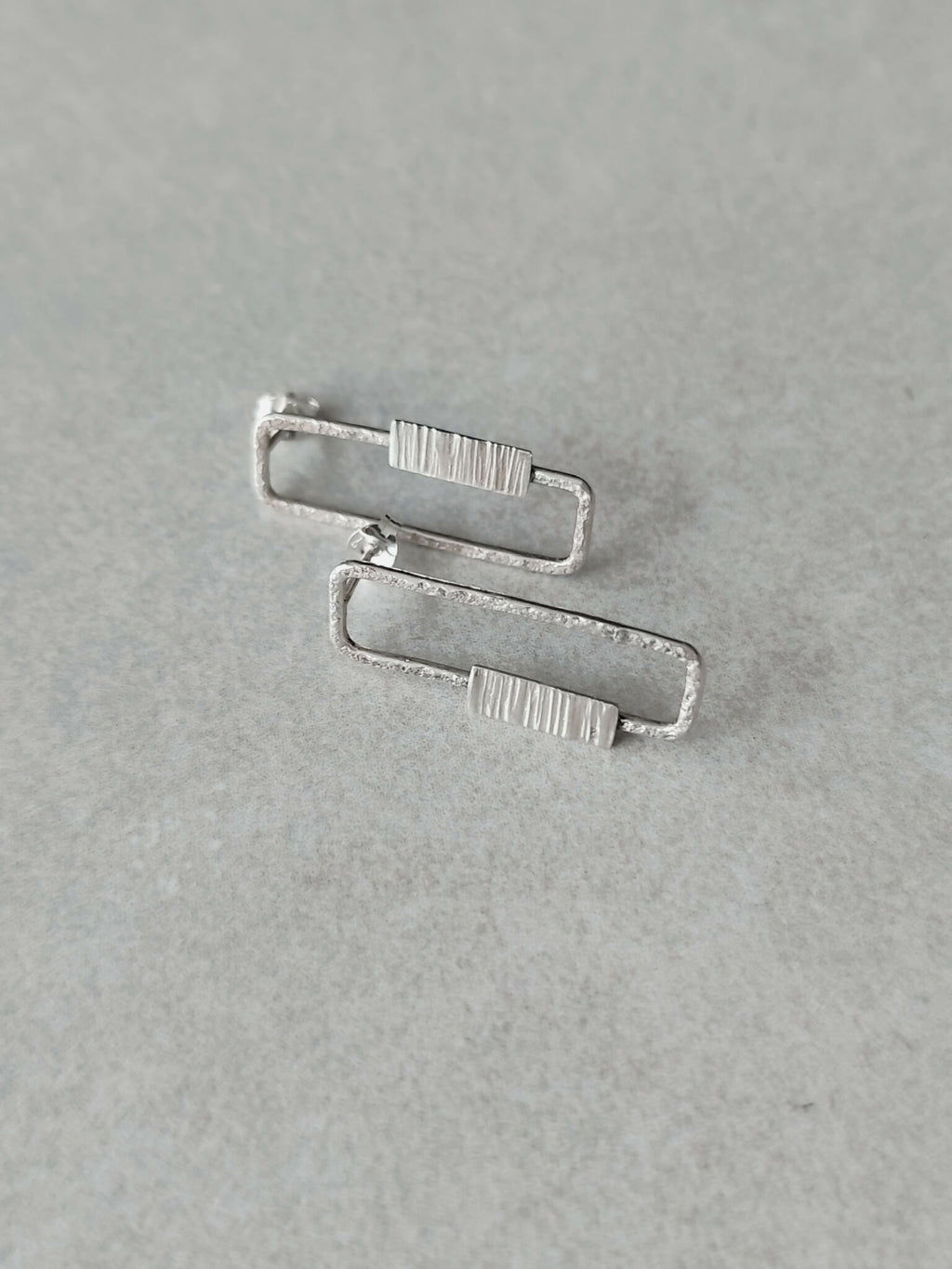 Boucles d’oreilles rectangulaires argentées, double paire superposée et rayée.