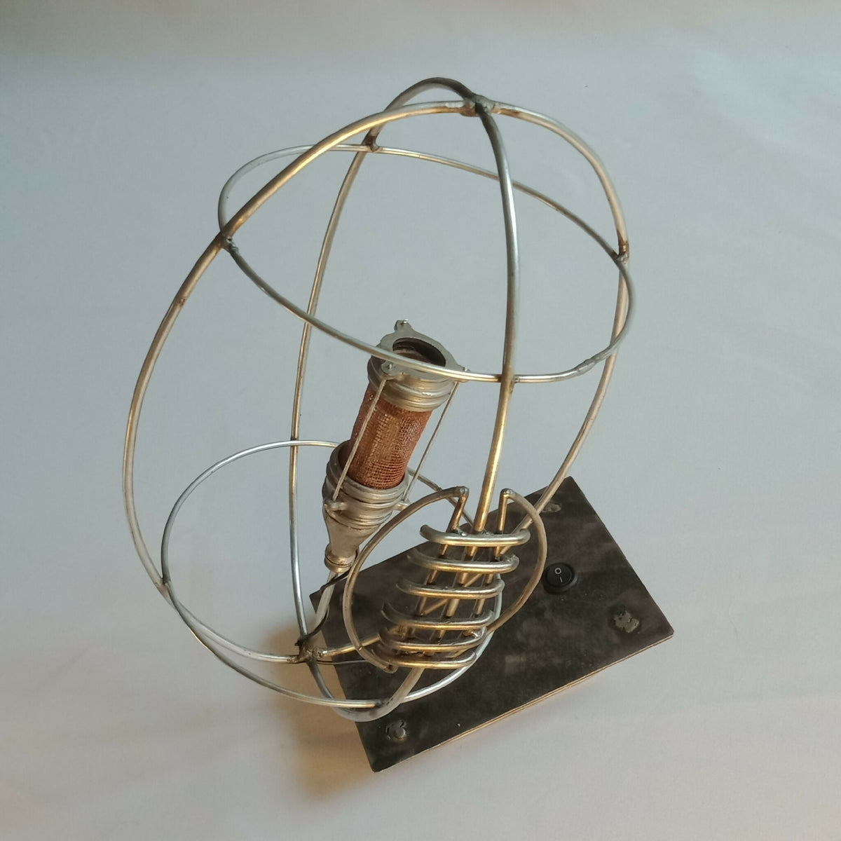 Lampe RUGBY cage dorée et ampoule sur socle noir, détail de l’abat-jour en treillis