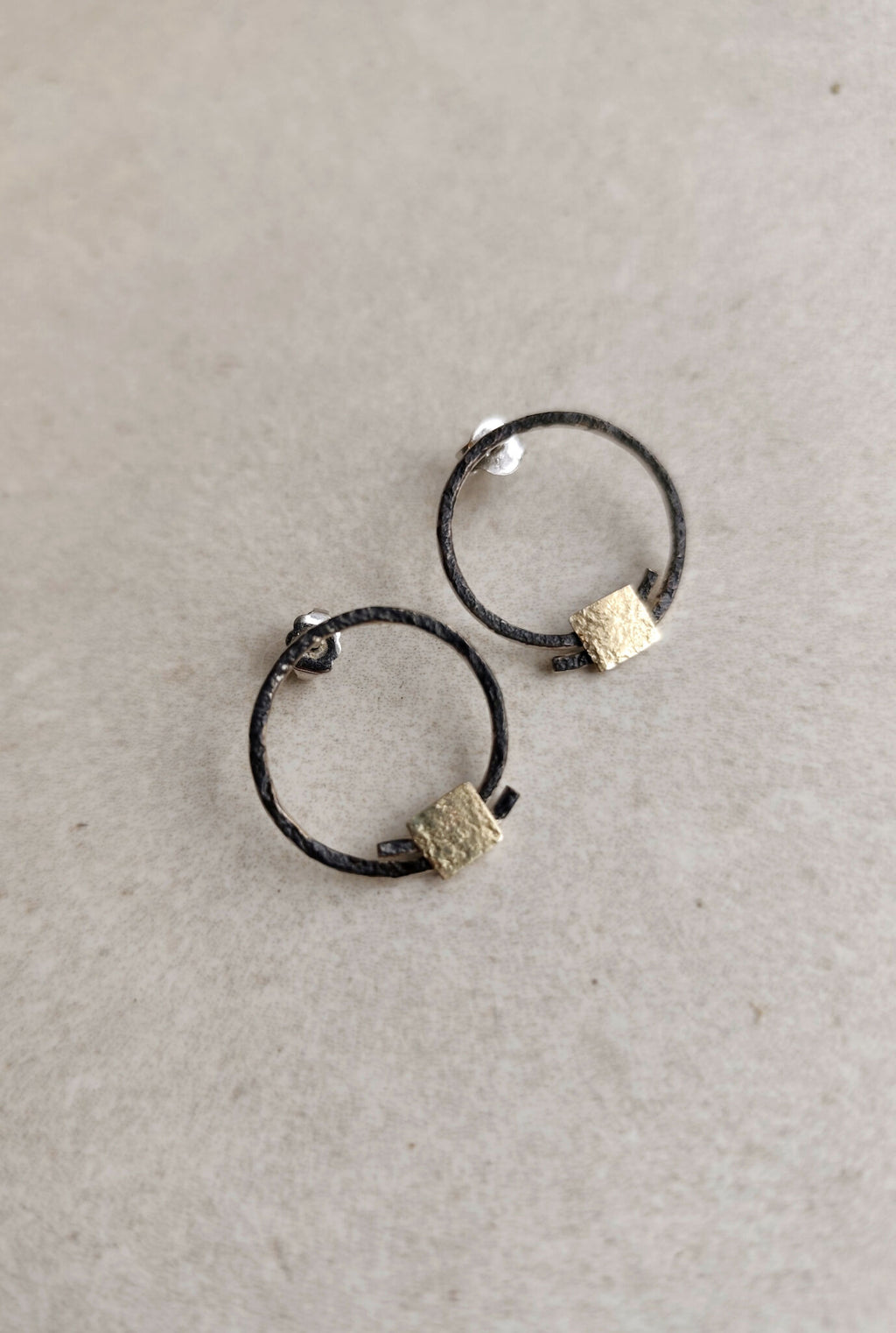 Boucles d’oreilles anneaux noirs, carrés texturés dorés, vue écartée
